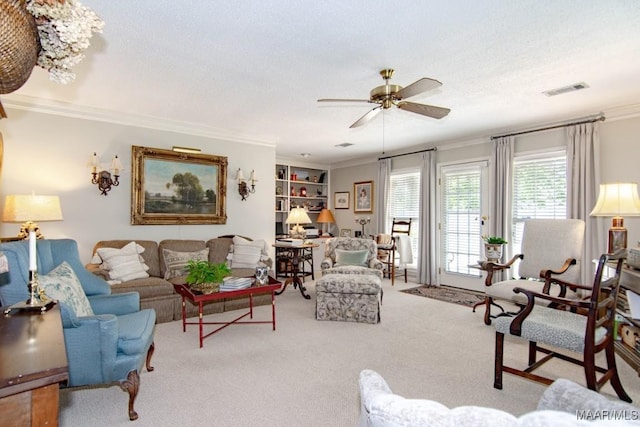 carpeted living area featuring ornamental molding, ceiling fan, and a textured ceiling