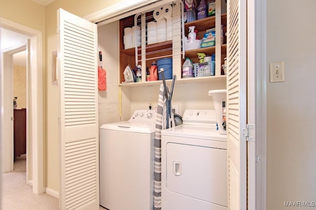 washroom with washer and dryer and light carpet