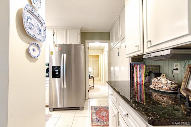 kitchen featuring stainless steel fridge with ice dispenser, light tile patterned flooring, white cabinets, under cabinet range hood, and dark stone counters
