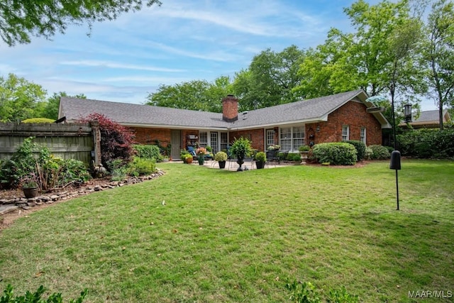 rear view of property featuring a chimney, a patio area, and brick siding