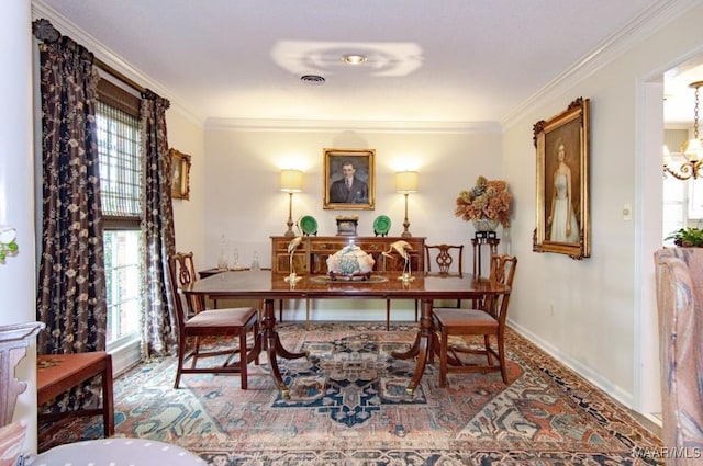 dining room featuring healthy amount of natural light, crown molding, baseboards, and a chandelier