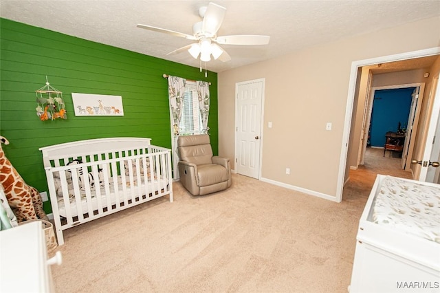 331 Bush Dr, Hope Hull, AL 36043 - bedroom featuring carpet floors, a nursery area, baseboards, a ceiling fan, and a textured ceiling