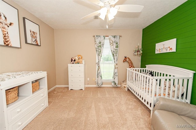 331 Bush Dr, Hope Hull, AL 36043 - bedroom featuring a crib, carpet flooring, baseboards, a ceiling fan, and a textured ceiling