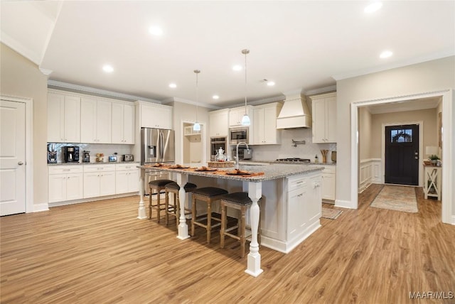 1412 Wildlife Way, Prattville, AL 36066 - kitchen with premium range hood, stainless steel appliances, a breakfast bar area, ornamental molding, and light wood finished floors