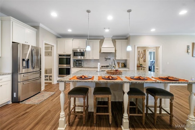 1412 Wildlife Way, Prattville, AL 36066 - kitchen featuring stainless steel appliances, custom exhaust hood, ornamental molding, tasteful backsplash, and a breakfast bar area