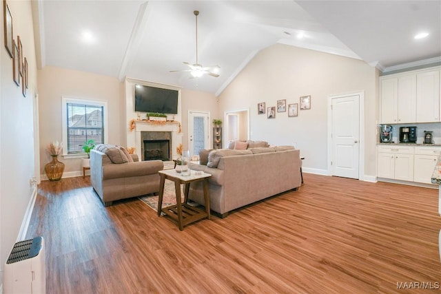 1412 Wildlife Way, Prattville, AL 36066 - living room with a fireplace, ceiling fan, baseboards, light wood-style floors, and high vaulted ceiling