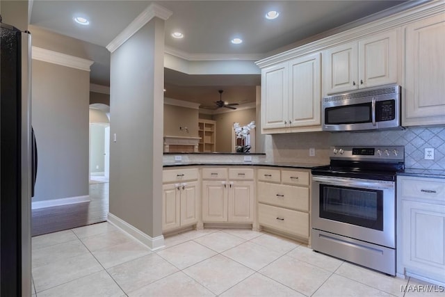 5906 Amberwood Ln, Montgomery, AL 36116 - kitchen featuring stainless steel appliances, ornamental molding, arched walkways, light tile patterned floors, and decorative backsplash