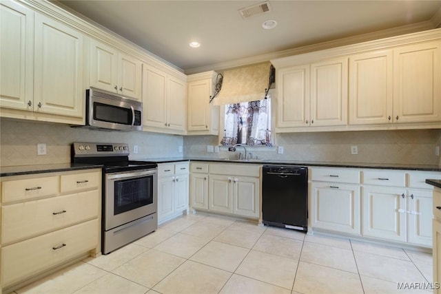 5906 Amberwood Ln, Montgomery, AL 36116 - kitchen with stainless steel appliances, dark countertops, decorative backsplash, light tile patterned flooring, and crown molding