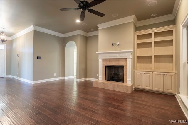 5906 Amberwood Ln, Montgomery, AL 36116 - unfurnished living room featuring arched walkways, ceiling fan, dark wood-type flooring, crown molding, and a tiled fireplace