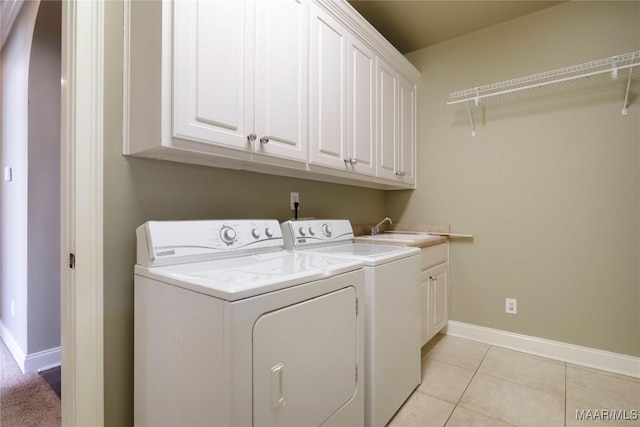 5906 Amberwood Ln, Montgomery, AL 36116 - washroom featuring separate washer and dryer, cabinet space, and light tile patterned floors