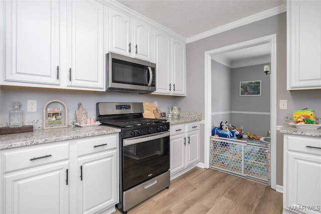 1274 Cross Creek Rd, Prattville, AL 36067 - kitchen featuring stainless steel appliances, light wood-style flooring, white cabinets, ornamental molding, and light stone counters
