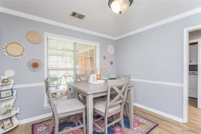 1274 Cross Creek Rd, Prattville, AL 36067 - dining area featuring wood finished floors, ornamental molding, washer / dryer, a textured ceiling, and baseboards