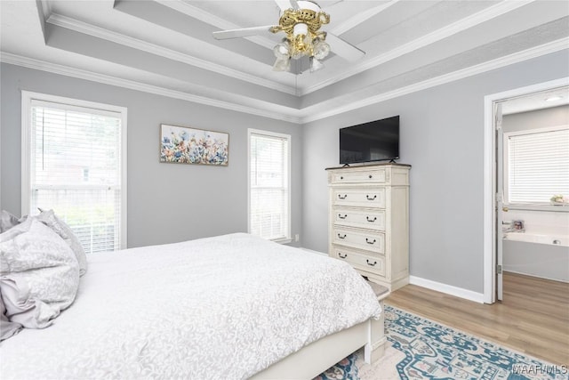 1274 Cross Creek Rd, Prattville, AL 36067 - bedroom featuring a tray ceiling, light wood-style flooring, crown molding, baseboards, and connected bathroom