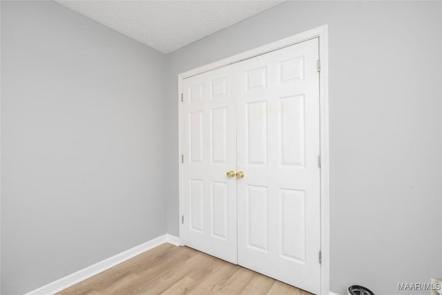 1274 Cross Creek Rd, Prattville, AL 36067 - unfurnished bedroom with light wood-style flooring, baseboards, a textured ceiling, and a closet