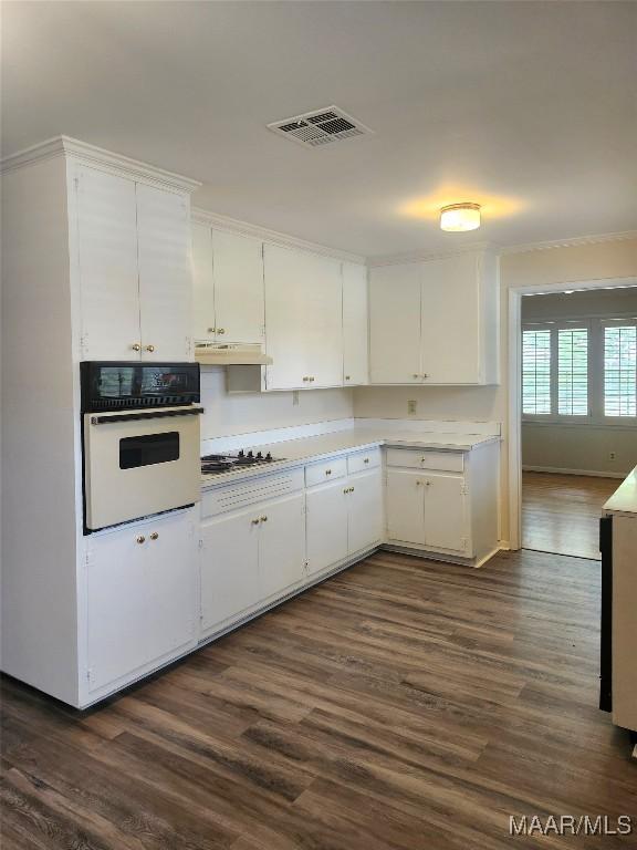 305 Sterling Dr, Montgomery, AL 36109 - kitchen with oven, gas stovetop, white cabinetry, dark wood-type flooring, and crown molding