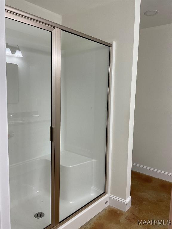 215 Indian Ln, Tallassee, AL 36078 - full bathroom with baseboards, a shower stall, and finished concrete floors