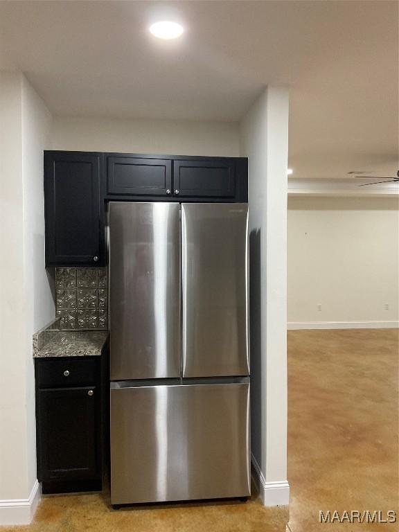 215 Indian Ln, Tallassee, AL 36078 - kitchen featuring freestanding refrigerator, baseboards, dark cabinetry, light stone countertops, and decorative backsplash