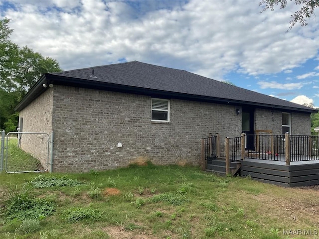 215 Indian Ln, Tallassee, AL 36078 - back of property featuring a wooden deck, brick siding, and a lawn