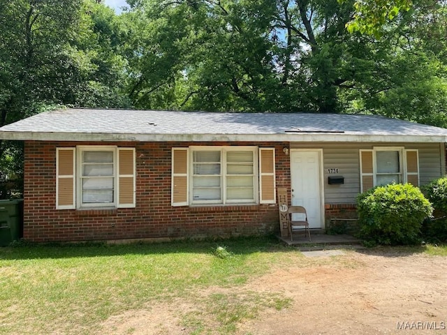 1734 Champion St, Montgomery, AL 36110 - view of front facade featuring brick siding, a front lawn, and roof with shingles