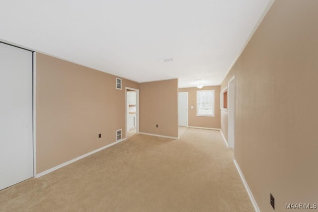 unfurnished room with light carpet and baseboards