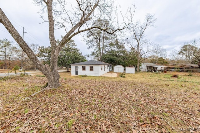 view of yard featuring a storage shed, an outdoor structure, and fence