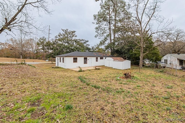 back of property with a storage shed and an outbuilding