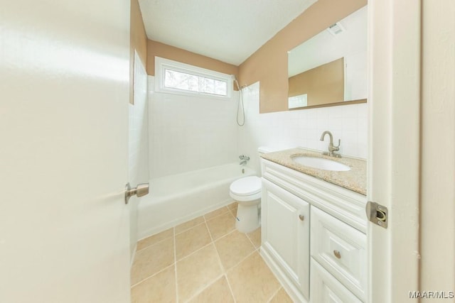 full bath featuring toilet, tile walls, vanity, shower / washtub combination, and tile patterned flooring