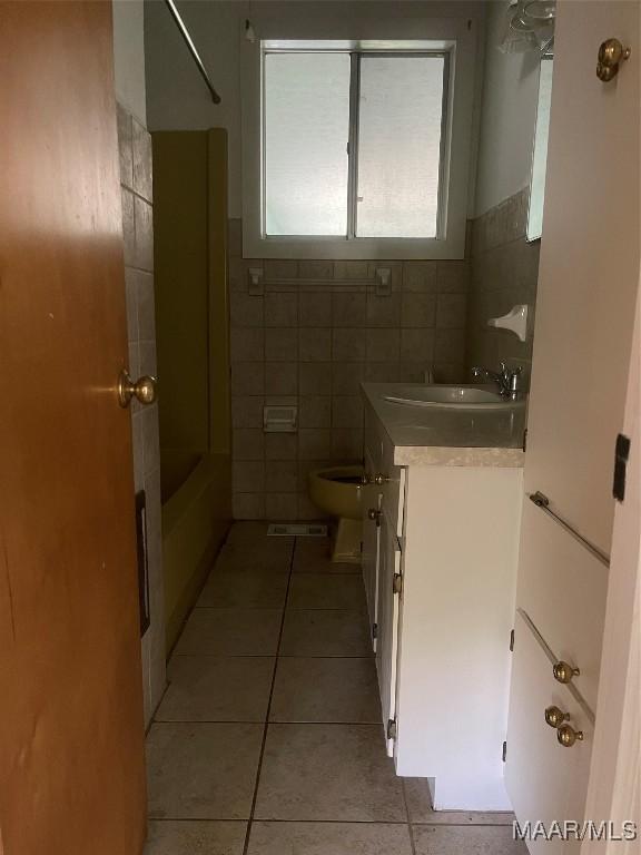 8130 Sorrel Ln, Montgomery, AL 36117 - bathroom featuring tile patterned floors, vanity, toilet, tile walls, and shower / bath combination