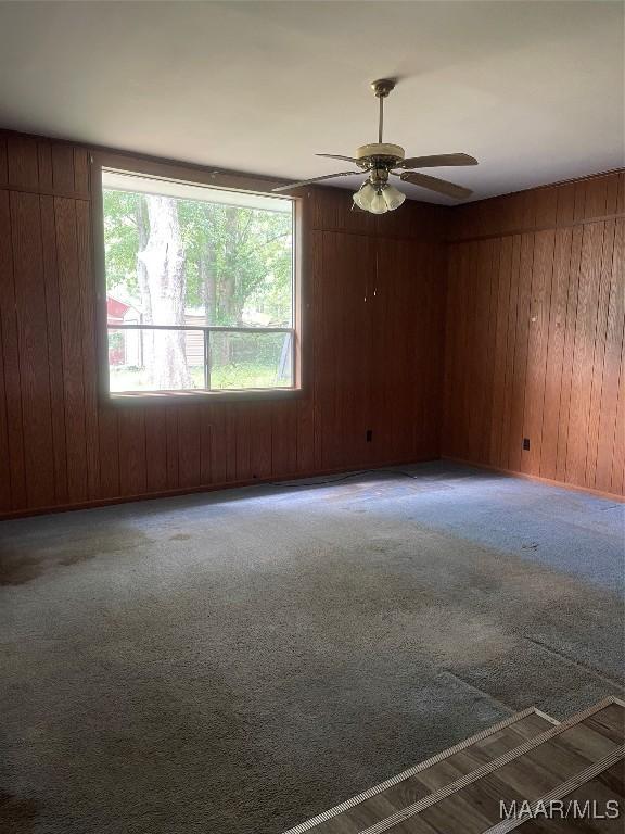 8130 Sorrel Ln, Montgomery, AL 36117 - carpeted empty room featuring wooden walls and ceiling fan