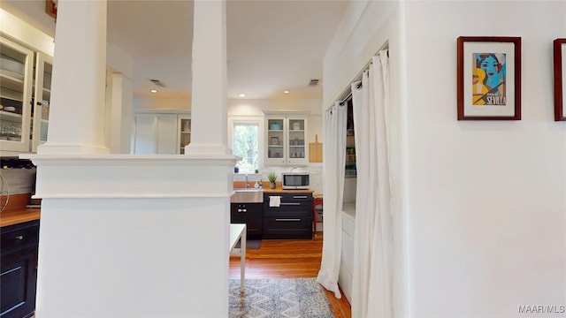 1207 Woodward Ave, Montgomery, AL 36106 - hallway featuring decorative columns, a sink, light wood-type flooring, and recessed lighting