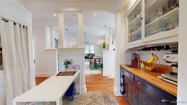 1207 Woodward Ave, Montgomery, AL 36106 - bar area with light wood-style flooring, ornate columns, a sink, and recessed lighting
