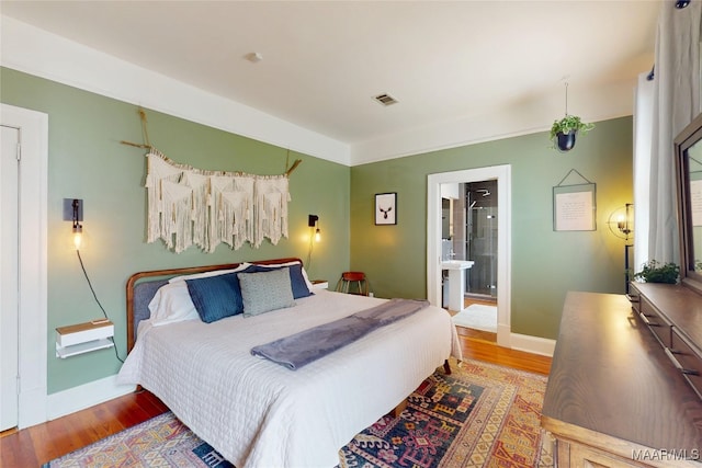 1207 Woodward Ave, Montgomery, AL 36106 - bedroom with wood finished floors, baseboards, and ensuite bathroom
