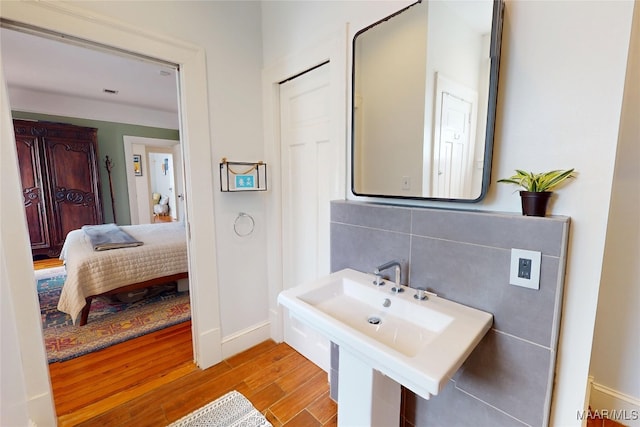 1207 Woodward Ave, Montgomery, AL 36106 - bathroom featuring wood finished floors, baseboards, ensuite bathroom, and a sink