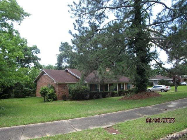 ranch-style home with a front yard and brick siding