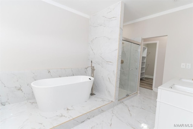 bathroom featuring crown molding, marble tiled floors, a marble finish shower, a freestanding tub, and vanity