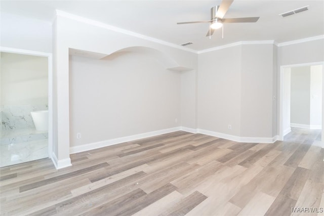 empty room featuring ceiling fan, crown molding, wood finished floors, and baseboards