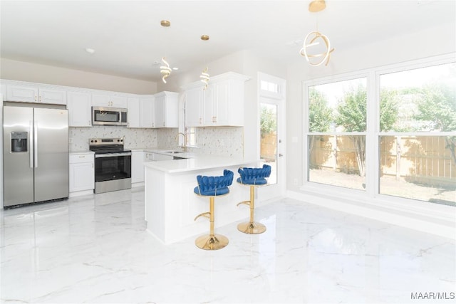 kitchen featuring stainless steel appliances, light marble finish flooring, tasteful backsplash, and a sink