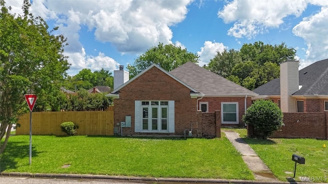 rear view of property featuring brick siding, a chimney, and roof with shingles