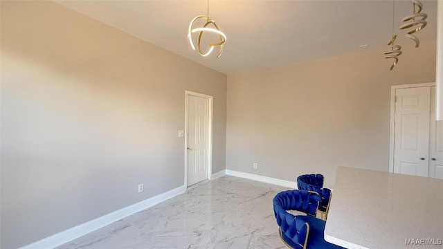 unfurnished room with light marble finish floors, baseboards, and a chandelier