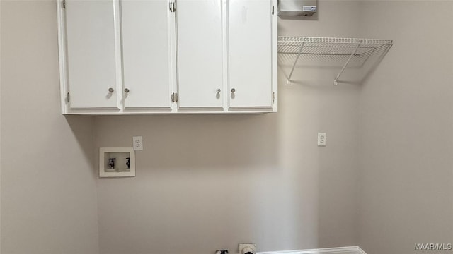 washroom with hookup for a washing machine, cabinet space, and baseboards