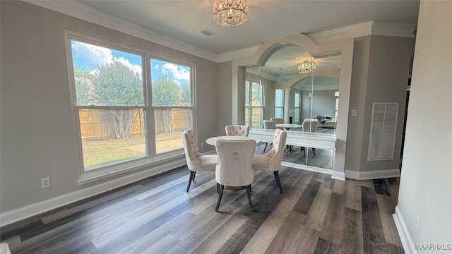 dining room with a chandelier, baseboards, crown molding, dark wood finished floors, and arched walkways