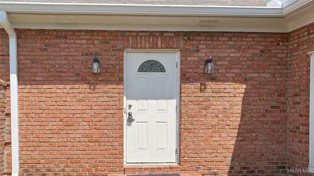 entrance to property featuring brick siding