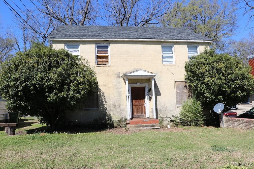 view of front of property with a front lawn and brick siding