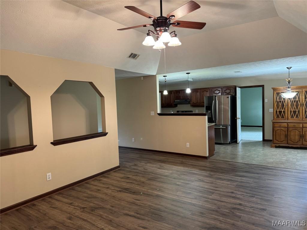 4030 Willowbrook Dr, Millbrook, AL 36054 - unfurnished living room with a ceiling fan, dark wood-style floors, baseboards, and vaulted ceiling