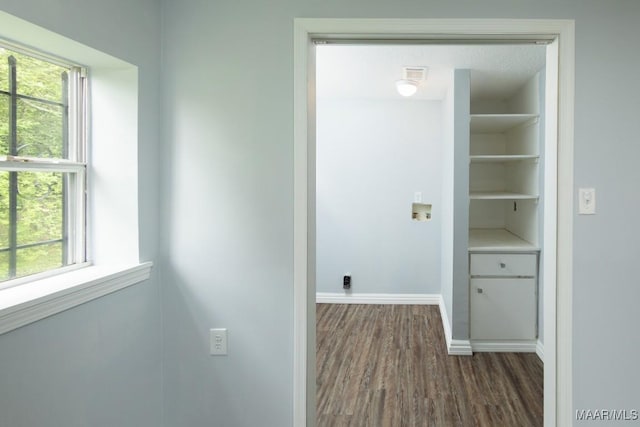 hallway featuring dark wood-style flooring and baseboards