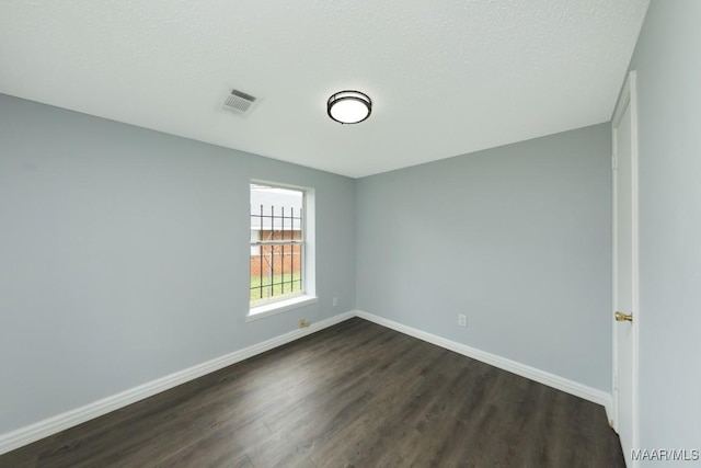 empty room with dark wood-style flooring and baseboards