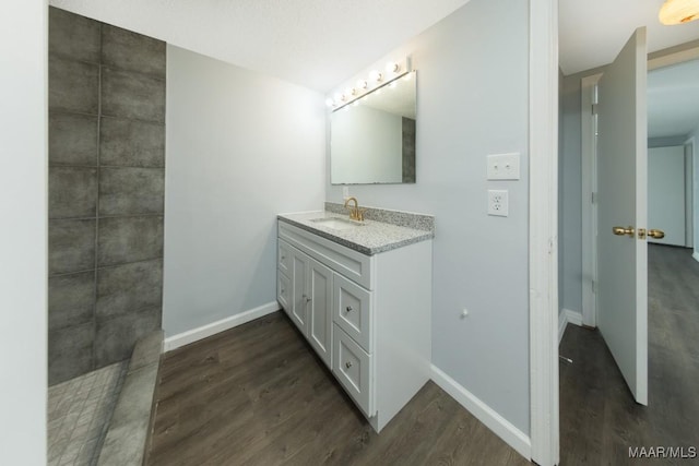 bathroom featuring wood finished floors, vanity, and baseboards