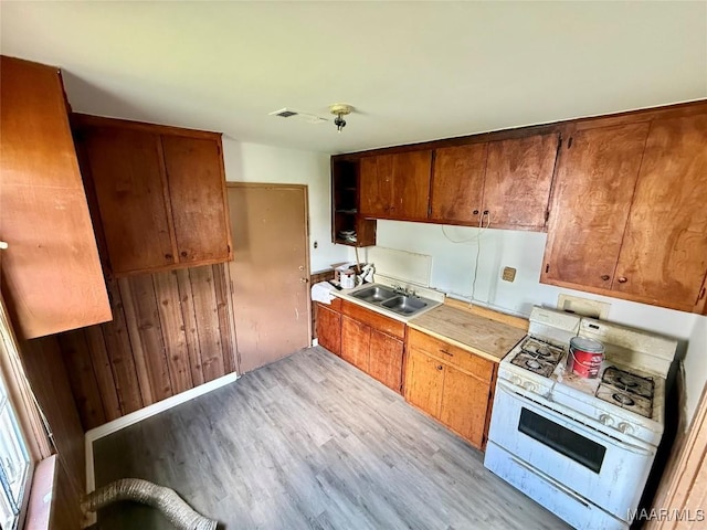 2620 Rutland St, Montgomery, AL 36108 - kitchen featuring white gas range, a sink, light wood finished floors, and light countertops