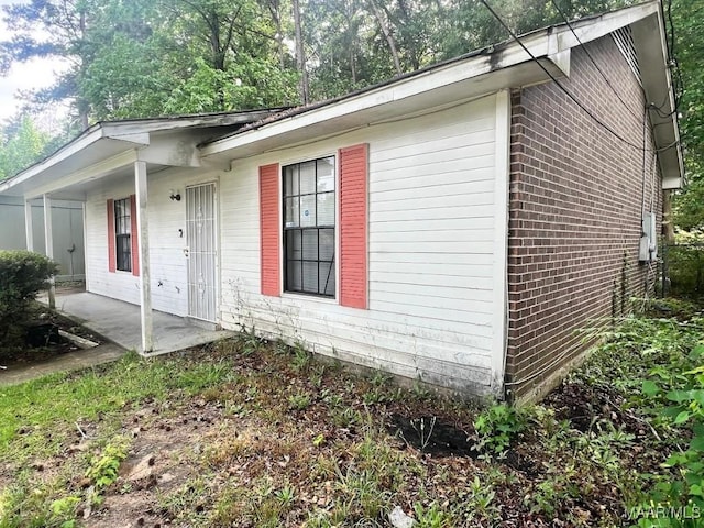 view of front of home featuring brick siding and a patio
