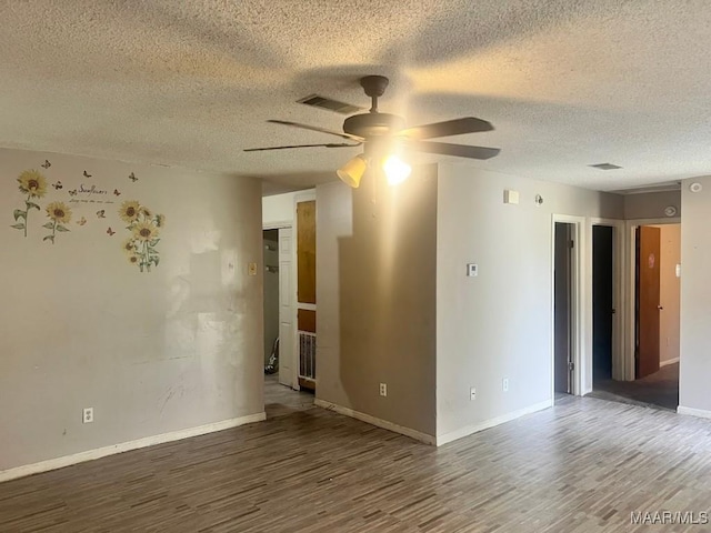 spare room featuring wood finished floors, ceiling fan, a textured ceiling, and baseboards